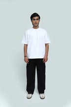 Person wearing a white t-shirt and black pants on a light gray background