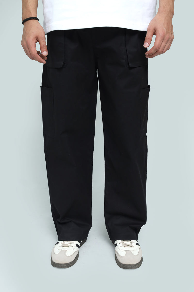 Person wearing black cargo pants on a light gray background