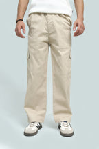 Person wearing beige cargo pants on a light gray background